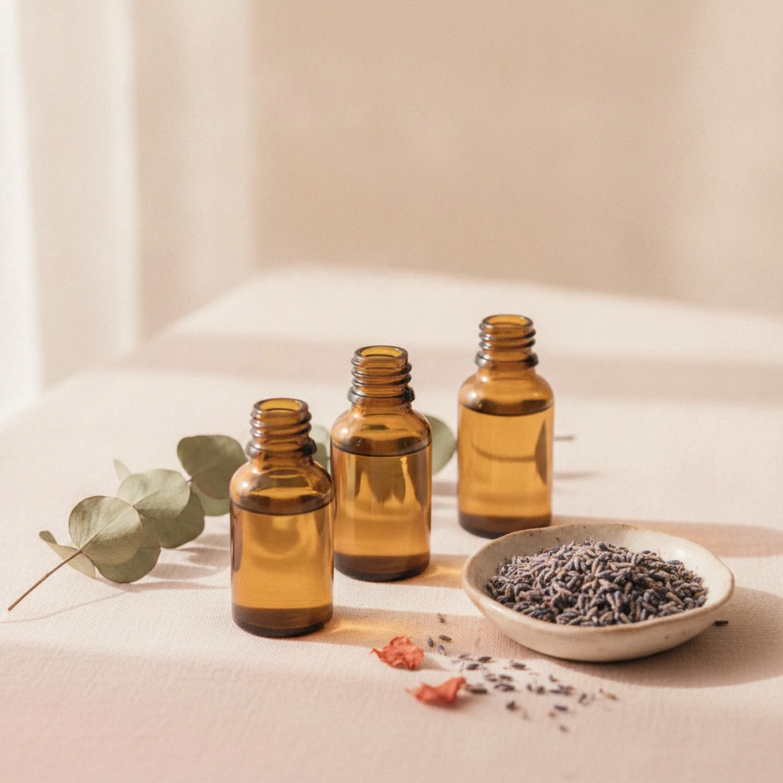 Amber essential-oil bottles with dried eucalyptus and lavender — stylized imagery